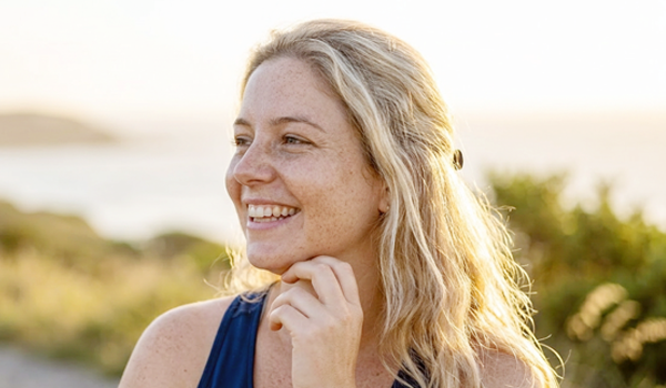 Mulher sorrindo ao ar livre durante o processo de emagrecimento